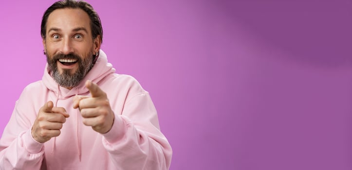 Thrilled energized charismatic happy lucky adult handsome bearded man pointing camera smiling widen eyes gazing impressed see famous person express amazement joy, purple background photo