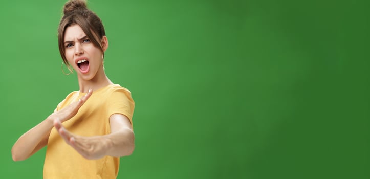 Not mess with this girl. Portrait of funny and emotive charismatic young woman standing in martial arts pose, showing fighting skills yelling kiya, open mouth frowning making karate movements photo