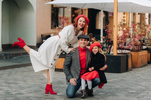 A stylish family of three strolls through the autumn city posing for a photographer . Dad, mom and daughter in the autumn city photo