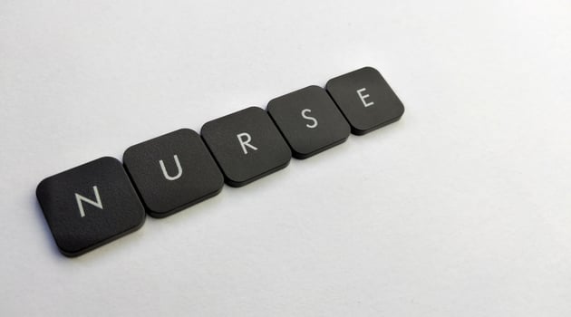 The word NURSE written with black buttons on a white background photo