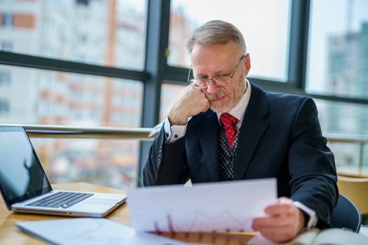 Thoughtful middle aged businessman in suit. Sitting near the window in office. Panoramic city view background. Business photo. photo