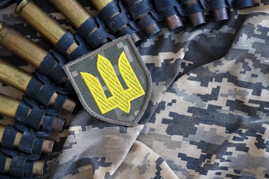 Ukrainian army symbol on machine gun belt lies on ukrainian pixeled military camouflage photo