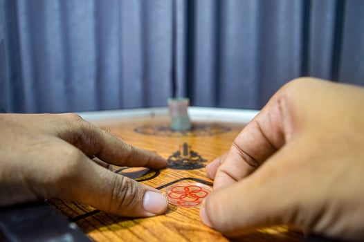 hands playing a traditional game called carom photo
