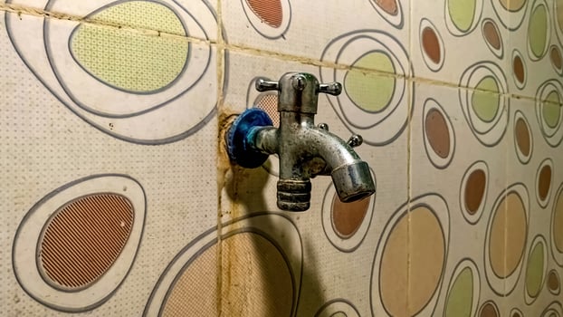 a water faucet attached to a ceramic wall with a polka dot pattern photo