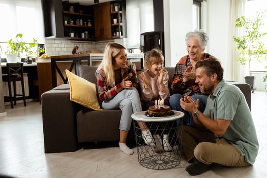 Joyous Family Celebrating Grandmothers Birthday With Cake in a Cozy Living Room photo