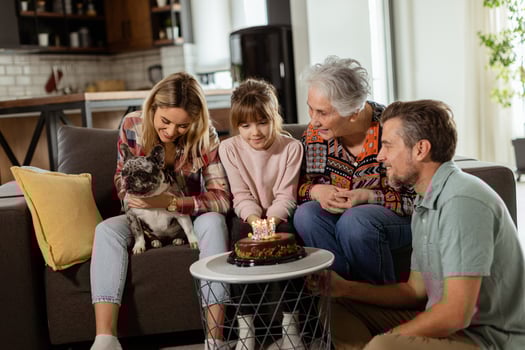 Joyous Family Celebrating Grandmothers Birthday With Cake in a Cozy Living Room photo