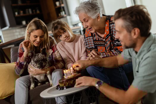 Joyous Family Celebrating Grandmothers Birthday With Cake in a Cozy Living Room photo
