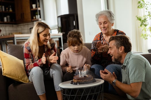 Joyous Family Celebrating Grandmothers Birthday With Cake in a Cozy Living Room photo