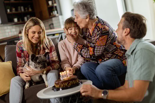 Joyous Family Celebrating Grandmothers Birthday With Cake in a Cozy Living Room photo