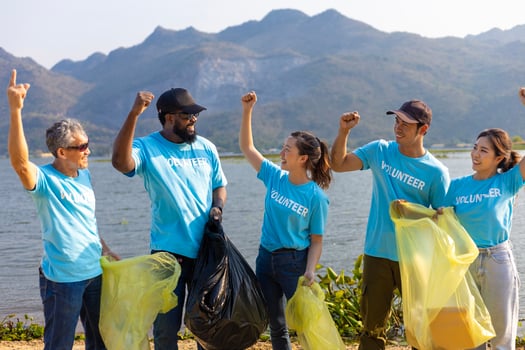 Team of young and diversity volunteer worker group enjoy charitable social work outdoor in cleaning up garbage and waste separation project at river beach photo