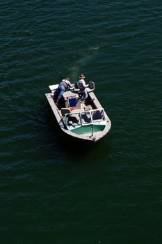 Sacramento, CA, 2012 - Two Men Fishing On Small Boat On River From Above photo