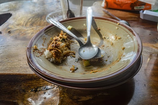a plate of leftovers with two spoons piled on top photo