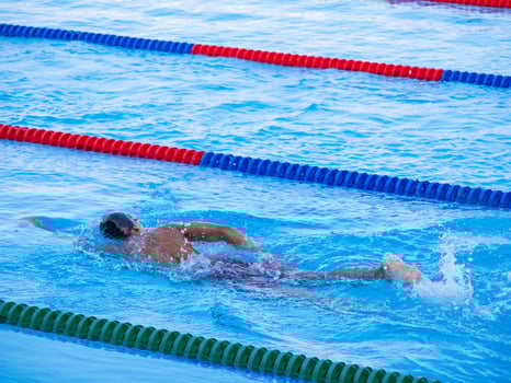 A young man swimming in an outdoor pool. Close-up photo. Concept of sport and healthcare photo