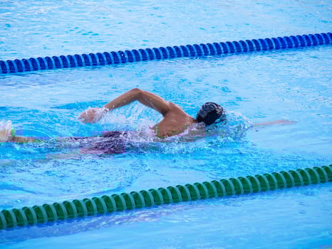 A young man swimming in an outdoor pool. Close-up photo. Concept of sport and healthcare photo