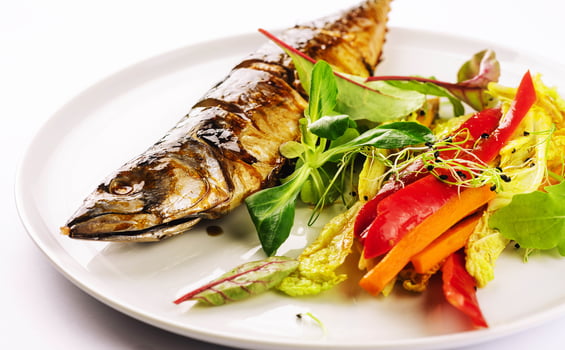 Baked mackerel with steamed vegetables on plate photo