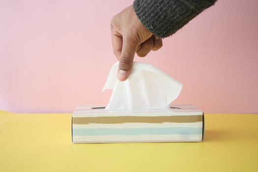 hand pull out a piece of tissue from tissue paper box photo