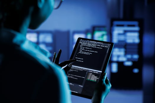 Close up of skilled worker running code and programming on laptop, troubleshooting and upgrading high tech facility designed to accommodate multiple clusters of fully operational server units photo