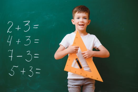 Funny schoolboy near the green school board in the classroom. Elementary school. Back to school. photo