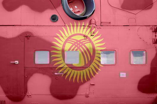Kyrgyzstan flag depicted on side part of military armored helicopter closeup. Army forces aircraft conceptual background photo