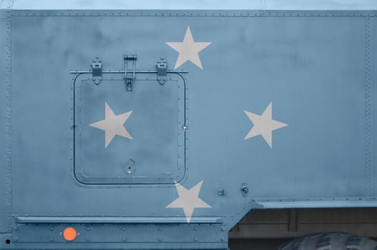 Micronesia flag depicted on side part of military armored truck closeup. Army forces conceptual background photo