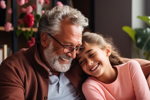 AI generated Happy grandfather and granddaughter hugging together on sofa indoors. Laughing cheerful caucasian grandpa and smiling little girl, family concept photo