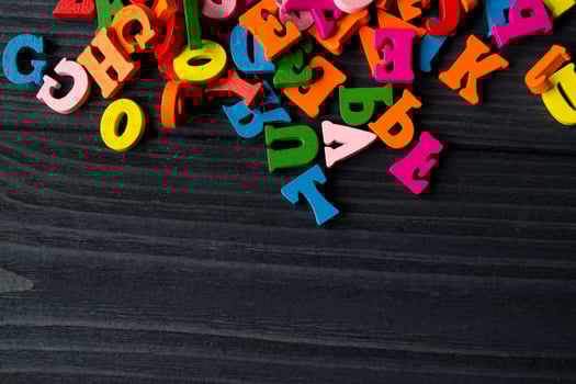 Multicolor letters on a dark blue wooden background. Colorful wooden alphabet on a table. photo