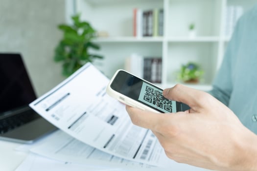 business man use phone to scan barcode or QR codes to pay credit card bill after receiving document invoice online. payment, receive, paying electricity, digital payments without money, technology photo