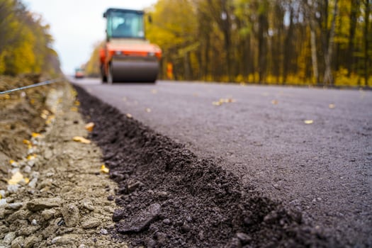 Road repair, compactor lays asphalt. Heavy special machines. Asphalt paver in operation. Side view. Closeup. photo