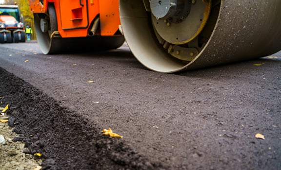 Heavy vibration roller at asphalt pavement works. Road repairing. Selective focus, cropped photo. New asphalt. photo