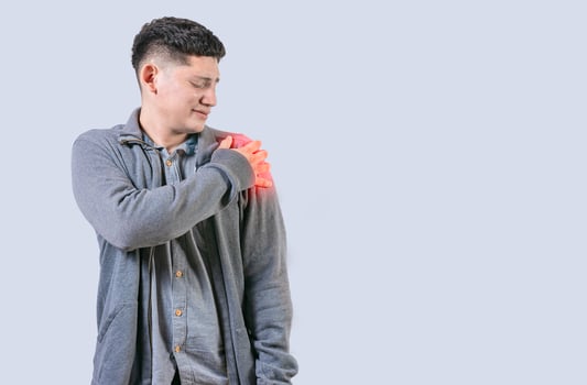 Person in pain holding his shoulder isolated. Youg man suffering with arms pain isolated photo