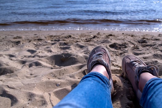 Female legs in sneakers on a sand. Relax on the beach. photo