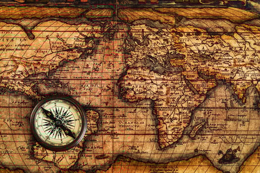 Old vintage compass on ancient map photo