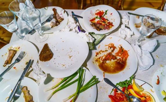Messy table after party. Leftover food, glasses, dirty dishes. photo