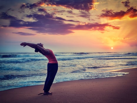 Young sporty fit woman doing yoga Sun salutation Surya Namaskar photo