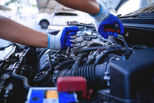 Close-up shot of auto mechanic's hands working on car engine in repair shop. car service technician Work in repair shops and maintenance services photo