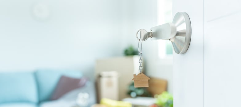 Moving house, relocation. The key was inserted into the door of the new house, inside the room was a cardboard box containing personal belongings and furniture. move in the apartment or condominium photo