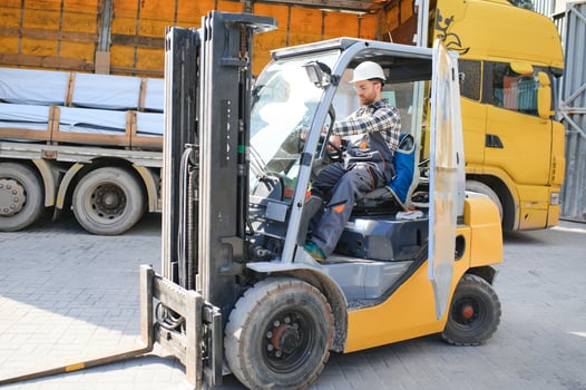 Portrait of professional forklift driver in factory's warehouse photo