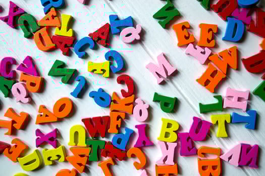 Multicolor letters on a white wooden background. Colorful wooden alphabet on a table. photo