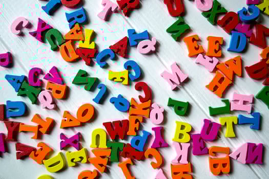 Multicolor letters on a white wooden background. Colorful wooden alphabet on a table. photo