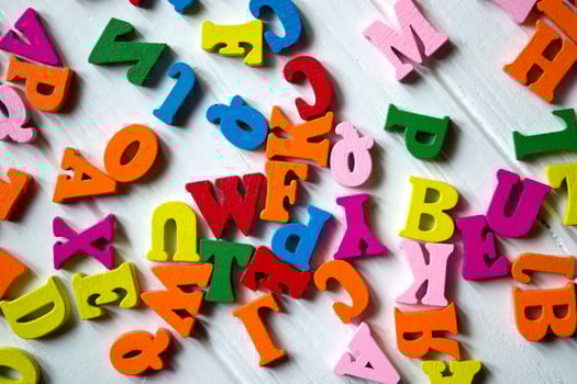 Multicolor letters on a white wooden background. Colorful wooden alphabet on a table. photo