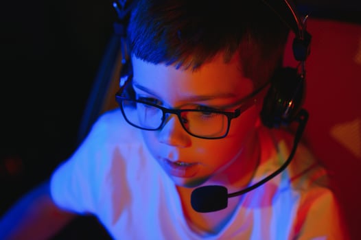 Little boy playing video game in the dark room photo