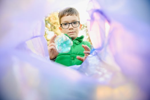 A seven-year-old boy at sunset is engaged in garbage collection in the park. Environmental care, recycling. photo