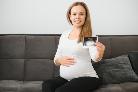 Pregnant woman hands holding ultrasound photo