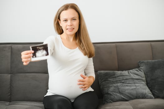 Pregnant women holding echo pictures in hand photo