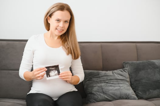 Pregnant women holding echo pictures in hand photo