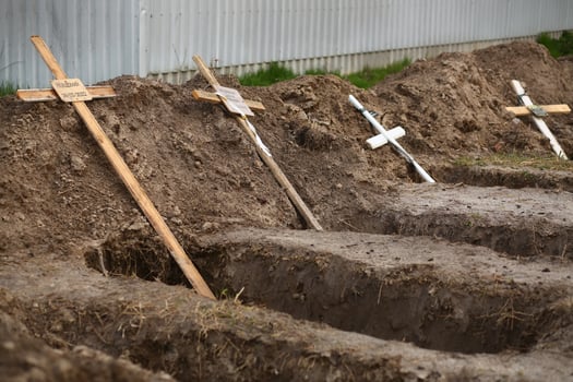 Bucha, Ukraine - April 12, 2022 Empty graves of the killed by the russian army civilans, buried by their neighbors in home yard, after exhumation of their bodies photo