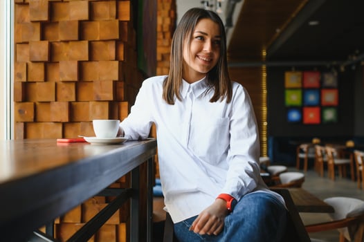 pretty young woman sitting in the cafe with a cup of tea photo