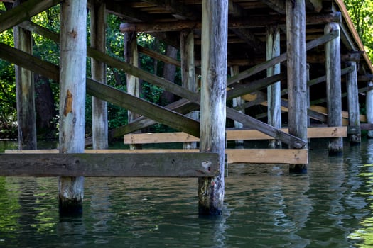 Wooden construction under bridge. Vintage bridge bottom view. photo
