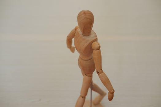 Wooden mannequin standing on a wooden background. Selective focus. photo