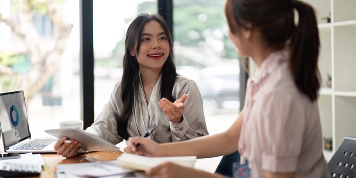 Two Asian businesswoman working with laptop computer and discussing documents and idea at meeting. Teamwork process photo